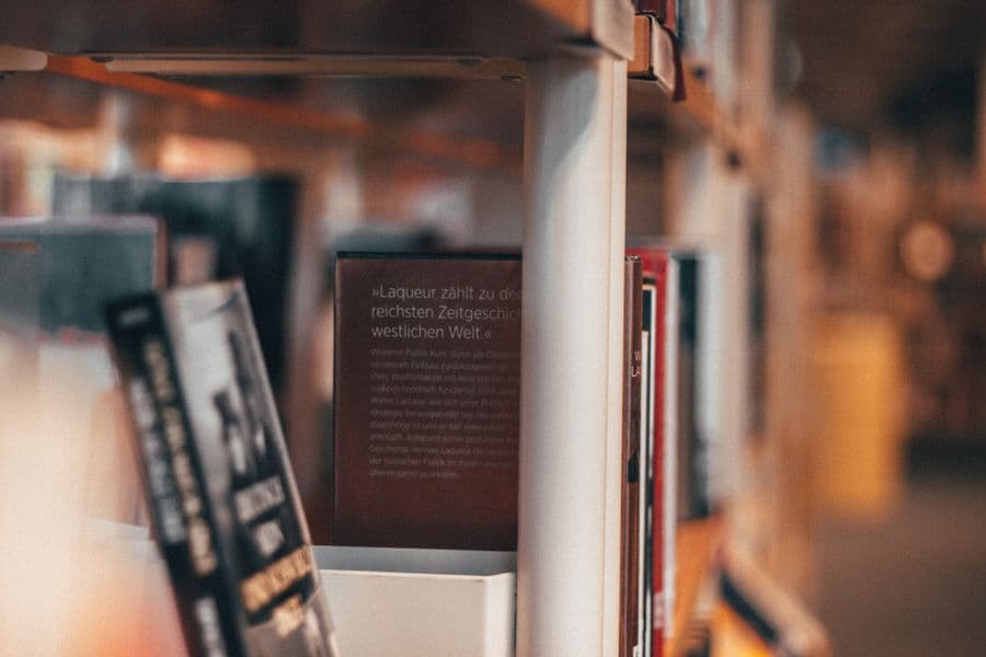 Rows of academic books on tall library shelves.