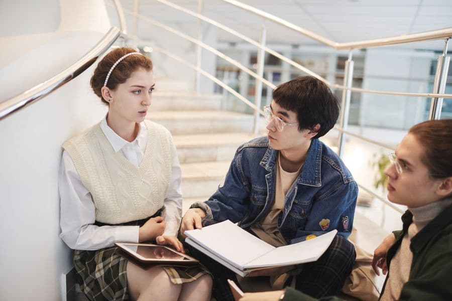 Students talking together on campus steps between sessions.